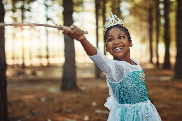 Children grow and learn with the power of their imagination Shot of a little girl dressed up as a princess and playing in the woods fancy dress costume stock pictures, royalty-free photos & images