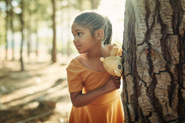 Shot of a little girl playing in the woods with her teddybear