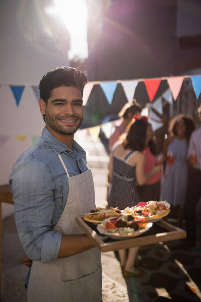 istock Happy waiter holding food in tray 811255146