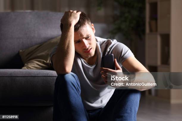 Sad Man Checking Mobile Phone Stock Photo - Download Image Now - Men, Sadness, Teenager