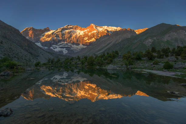 istock Sunlit mountain reflecting in lake 811259456