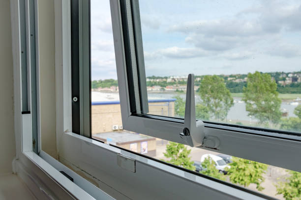 Apartment window shown opened to allow cool air in to the apartment room. Close-up of a newly installed double glazing system installed in an apartment. Outside can be seen a semi rural location with a distant river in the United Kingdom. window latch stock pictures, royalty-free photos & images