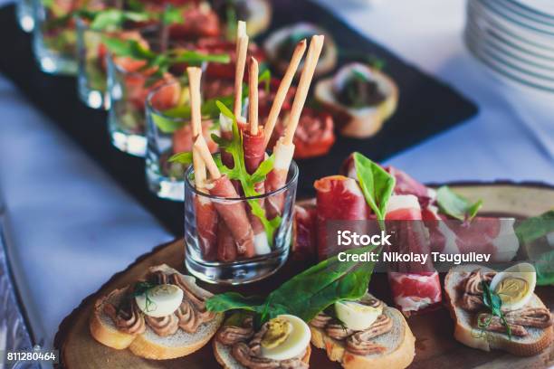 Beautifully Decorated Catering Banquet Table With Different Food Snacks And Appetizers On Corporate Christmas Birthday Party Event Or Wedding Celebration Stock Photo - Download Image Now