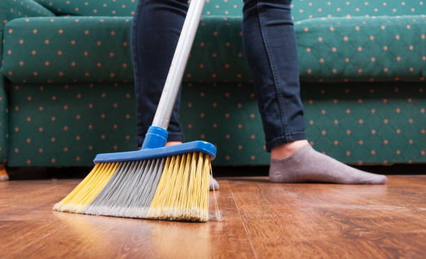 istock Cleaning woman sweeping wooden floor 811298496