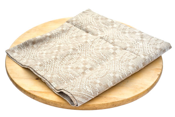 istock Beige linen sack burlap napkin on a round cutting board isolated on white background. 811303130