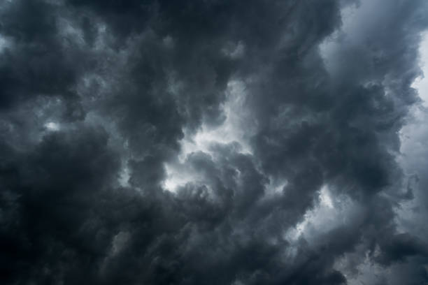 istock clouds with background,sunlight through very dark clouds background of dark storm clouds,black sky Background of dark clouds before a thunder. 811313706