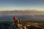 Friends on mountain top looking to sunset