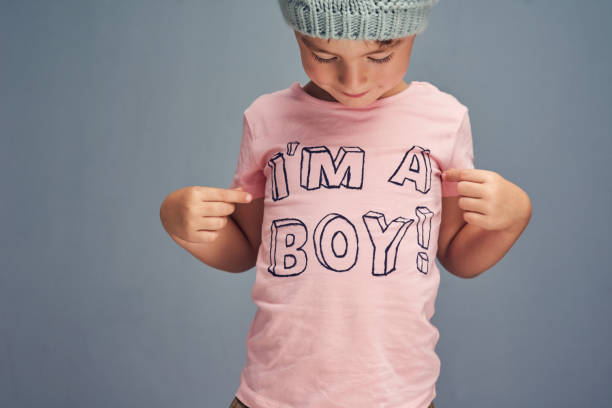 Who said boys can't wear pink? Studio shot of a boy wearing a t shirt with “I’m a boy” printed on it against a gray background graphic t shirt stock pictures, royalty-free photos & images