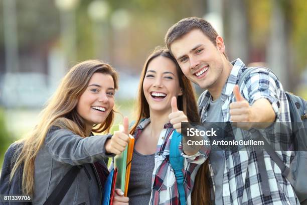 Tres Estudiantes Felices Con Los Pulgares Para Arriba Foto de stock y más banco de imágenes de Estudiante