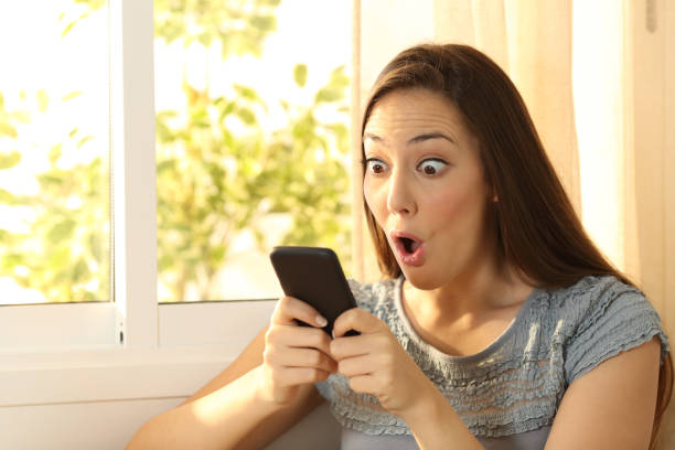 istock Amazed girl watching content on smart phone 811355970