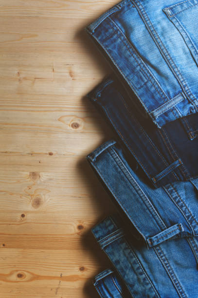 istock Blue denim jeans on wooden table. 811356012