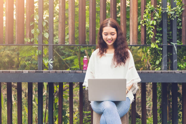 young asian woman happy using laptop connection and surfing internet at home on weekend - hipster people surfing the net internet imagens e fotografias de stock