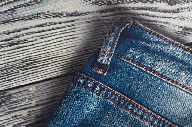 istock Closeup of blue denim jeans on wooden table 811356202