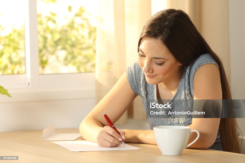 Jeune fille écrivant sur une table - Photo de Écrire libre de droits