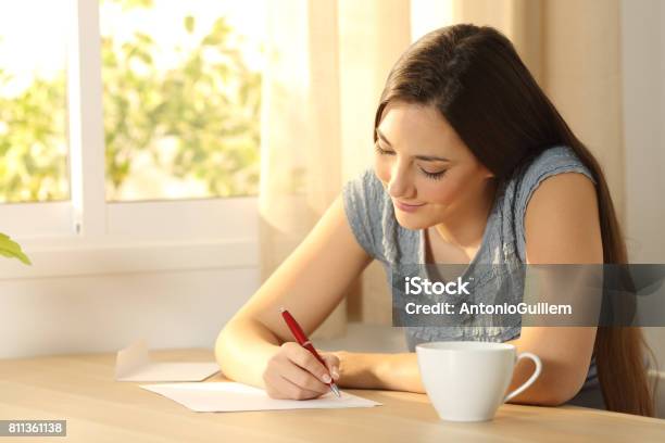 Photo libre de droit de Jeune Fille Écrivant Sur Une Table banque d'images et plus d'images libres de droit de Écrire - Écrire, Lettre - Document, Service postal