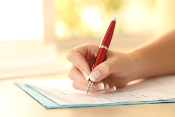 istock Woman hand filling form on a table 811365276
