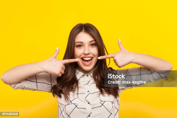 Woman Smiling And Pointing At Mouth Stock Photo - Download Image Now - Smiling, Pointing, Teeth