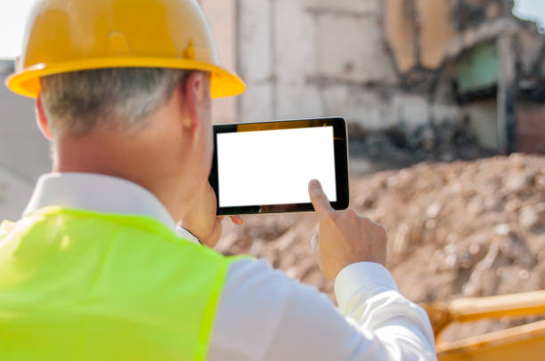 istock Mature engineer man in suit and helmet working on tablet pc. 811400368