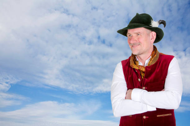 portrait of bavarian man in traditional clothes looking up to blue sky