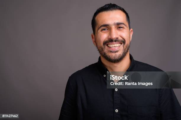 Photo libre de droit de Prise De Vue Studio Homme Daffaires De Perse Barbu Vêtu Dune Chemise Noire Sur Fond Gris banque d'images et plus d'images libres de droit de Hommes