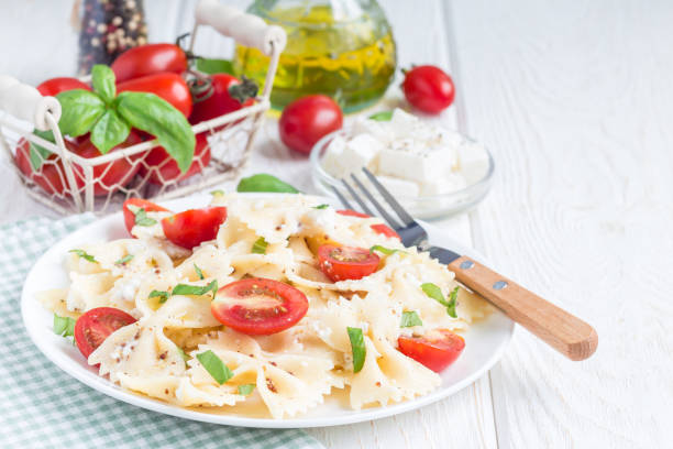 istock Pasta salad with tie pasta, feta cheese, tomatoes, mustard and basil, copy space, horizontal 811428108