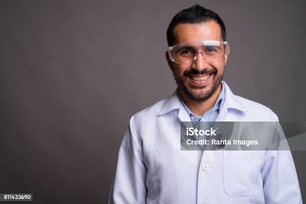 Studioaufnahme Des Bärtigen Persische Arzt Vor Grauem Hintergrund Stockfoto und mehr Bilder von Wissenschaftsberuf