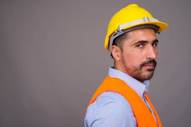 istock Studio shot of bearded Persian man construction worker against gray background 811433954