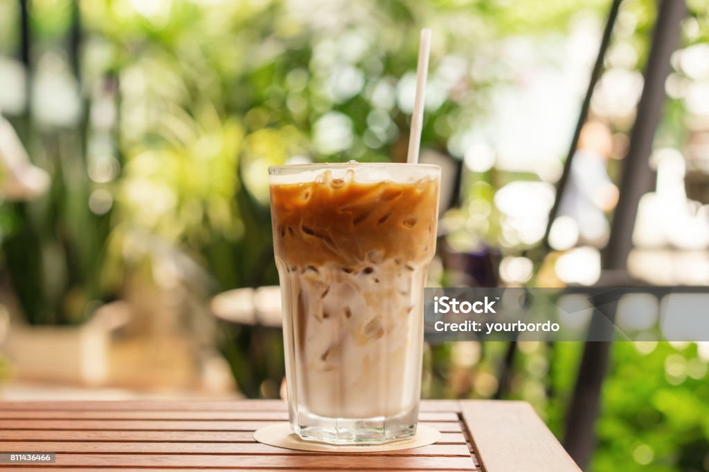 Glass of Iced coffee on the wood table, summer day, close up Latte Stock Photo