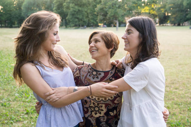 istock Mother and daughters embracing in a park 811441876