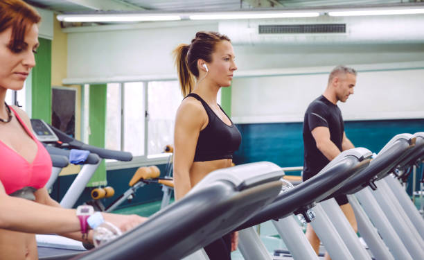 istock Woman with earphones training over a treadmill 811441928