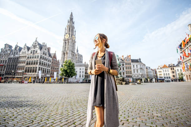 Woman traveling in Antwerpen city, Belgium Young woman tourist walking on the Great Market square during the morning in Antwerpen, Belgium flanders belgium photos stock pictures, royalty-free photos & images