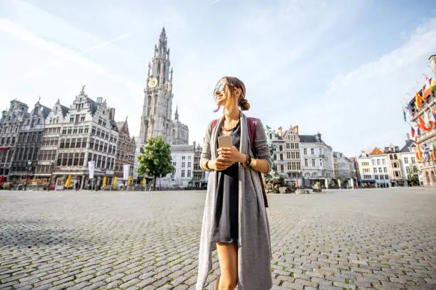 Young woman tourist walking on the Great Market square during the morning in Antwerpen, Belgium