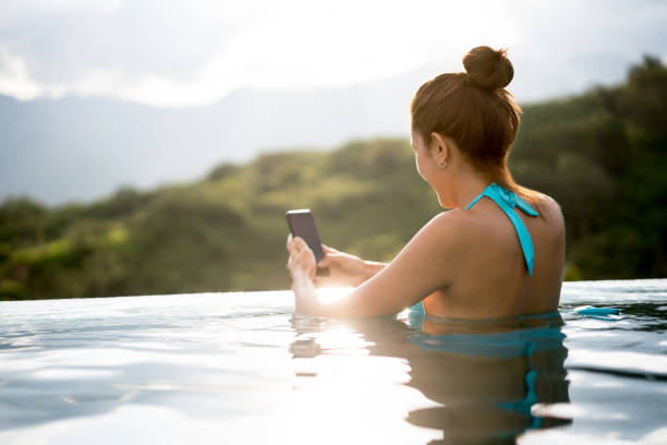 istock Woman texting in the swimming pool while relaxing 811453980
