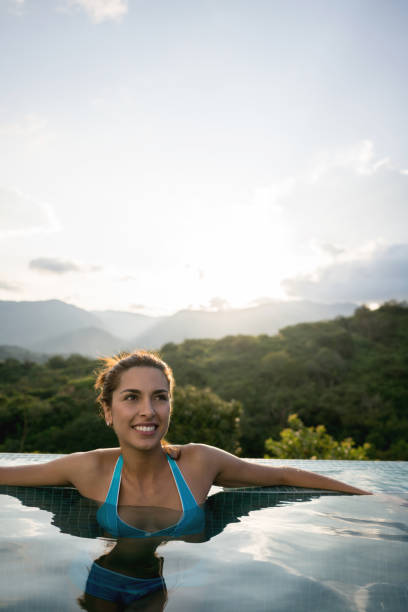 istock Happy woman on vacations relaxing in the pool 811454002