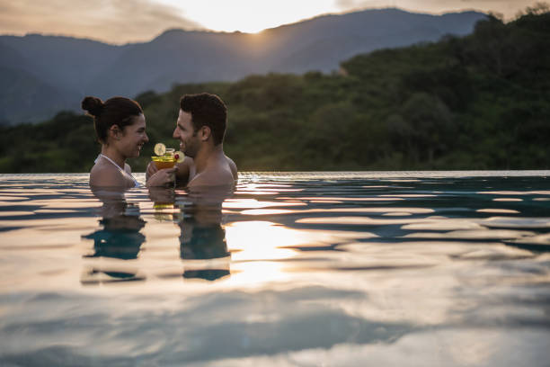 istock Romantic couple drinking a cocktail in the pool 811454102