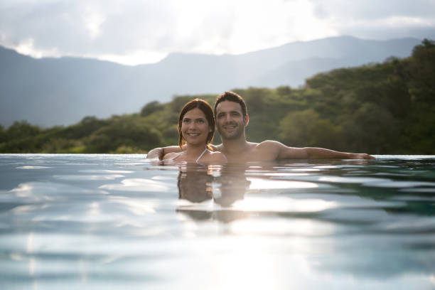 istock Happy couple relaxing in the pool while traveling 811454116