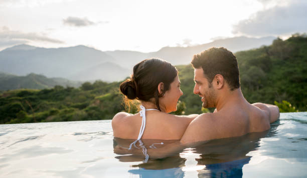 istock Loving couple in the pool enjoying their vacations 811454184