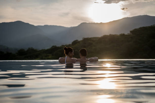 istock Couple on vacations enjoying a beautiful sunset at the pool 811454208