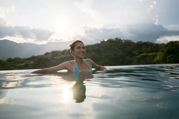 istock Woman on holidays relaxing by the pool 811454228
