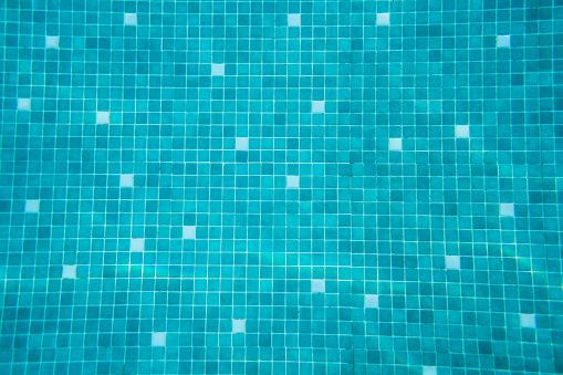 Floating bench seat, sitting zone in swimming pool with clean clear water, nobody. Square shaped pool with blue tiles, no people. Summer background.