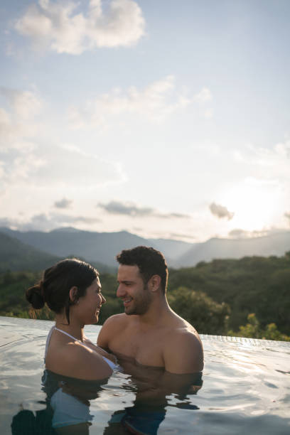 istock Couple in the pool enjoying a romantic getaway 811454304