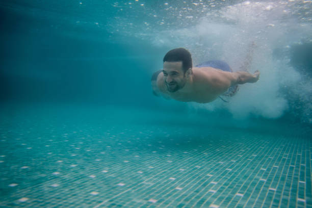 istock Happy man swimming in the pool with his partner 811454334