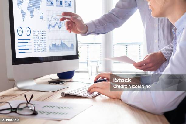 Two People Analyzing Stock Market Investment Strategy On Computer Stock Photo - Download Image Now