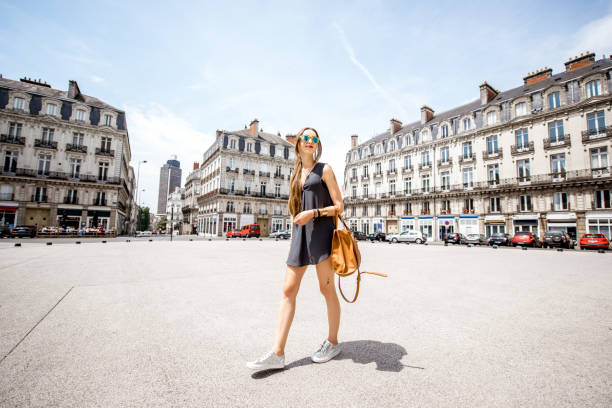 Woman traveling in Nantes city, France Young woman walking with bag on saint Pierre square with famous Brittany tower on the background in Nantes city in France nantes stock pictures, royalty-free photos & images