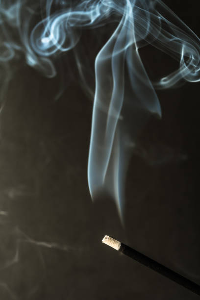istock Burning incense sticks with smoke on dark background 811467982