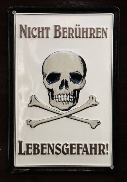 The text written in German: Nicht Berühren Lebensgefahr, which translated means not touching, danger of death Skull with two crossed shinbone with the text written in German: Nicht Berühren Lebensgefahr, which translated means not touching, danger of death berühren stock pictures, royalty-free photos & images