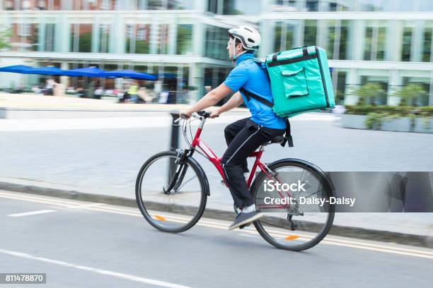 Courier On Bicycle Delivering Food In City Stock Photo - Download Image Now - Delivery Person, Delivering, Food