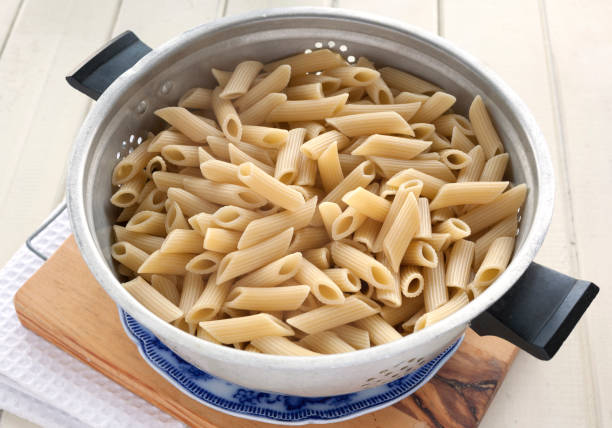 istock Penne pasta in an old colander - Hight angle view 811479018