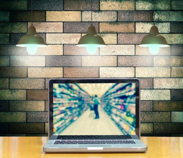 Computer notebook on brick wall background with Luxury lighting decoration show Abstract blurred photo of store bokeh background, online shopping concept Computer notebook on brick wall background with Luxury lighting decoration show Abstract blurred photo of store bokeh background, online shopping concept mark goodson screening room stock pictures, royalty-free photos & images