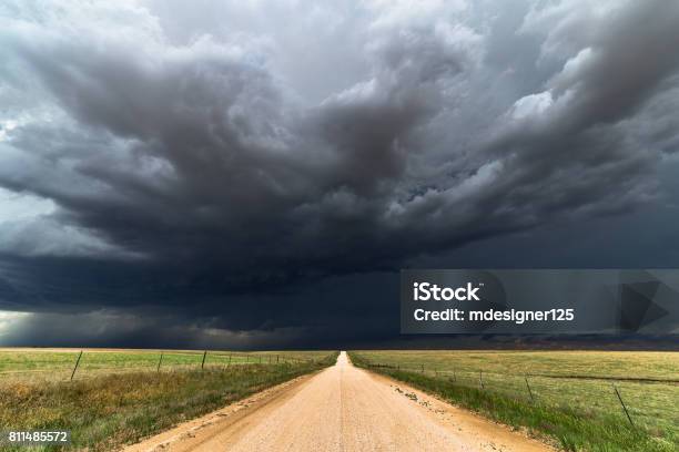 Dark Storm Clouds Over A Dirt Road Stock Photo - Download Image Now - Storm Cloud, Storm, Thunderstorm
